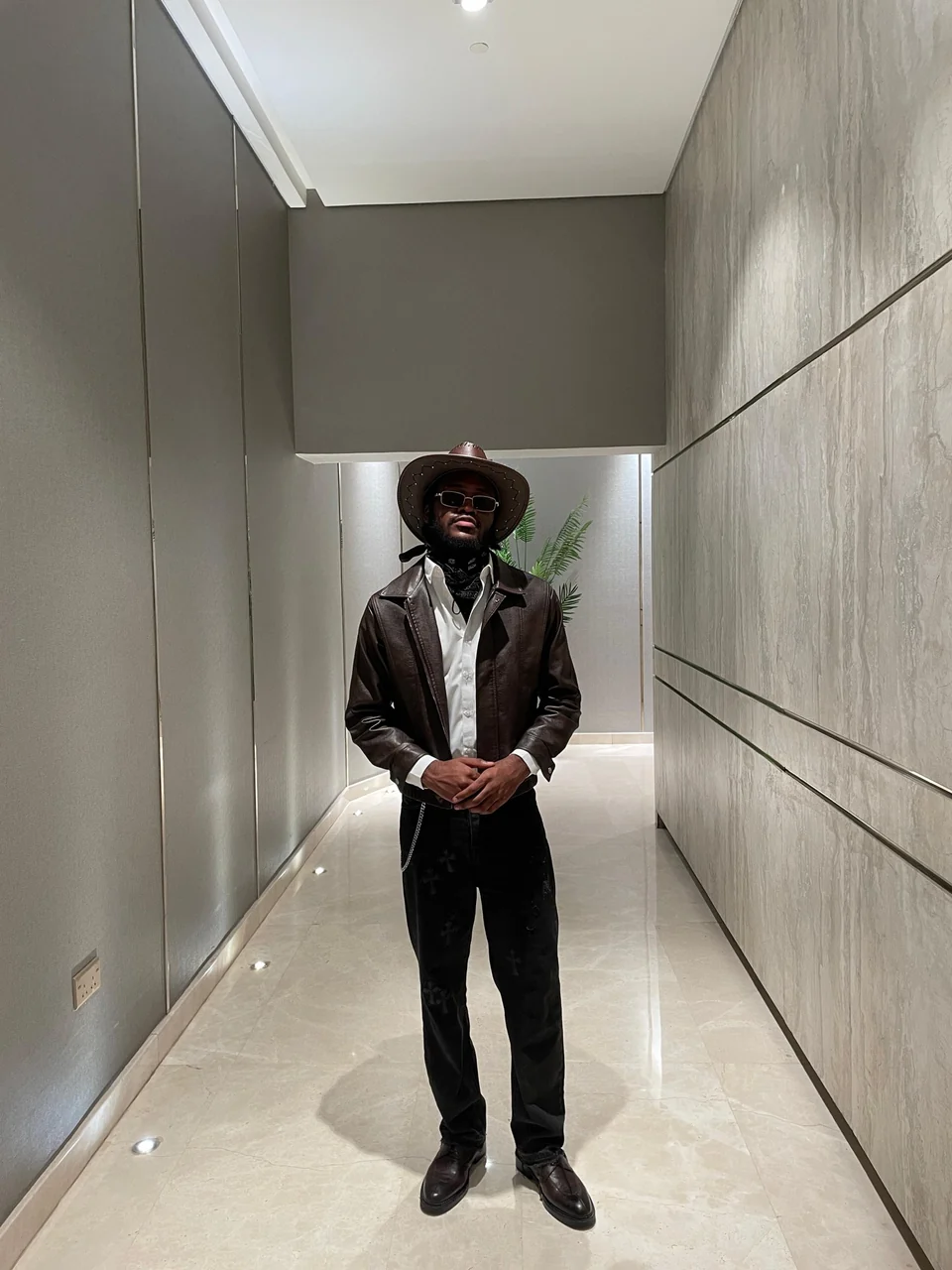 Mr. DURBA in a black silhouette in a contemporary passageway