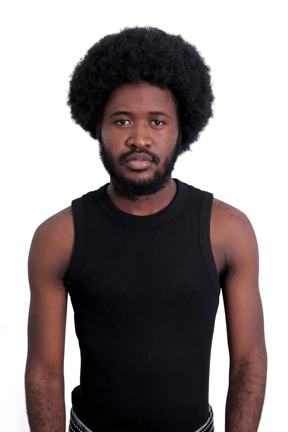 Frontal studio portrait of Mr. DURBA in a black vest against a light background